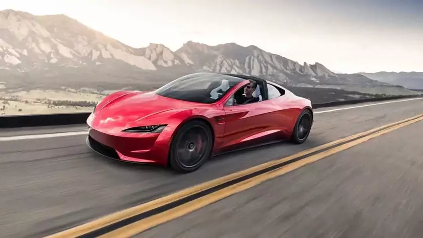Красный Tesla Roadster на дороге