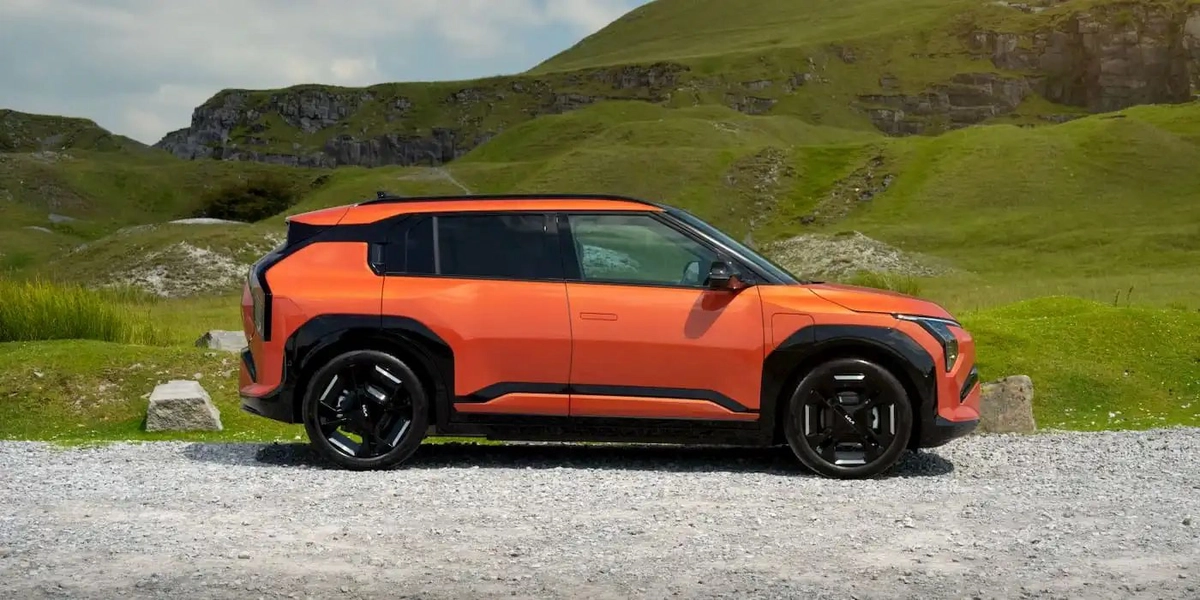 Kia EV4 на фоне холмов, вид сбоку