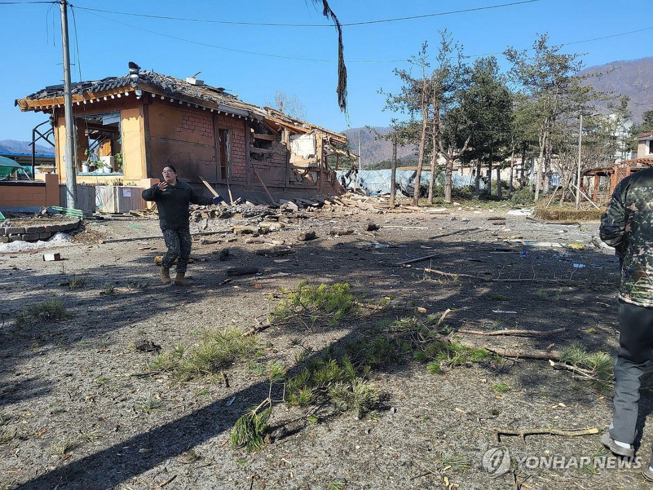 Military officials inspect the area where the bombs were dropped in Pochon